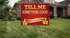 A red yard sign with gold lettering that reads &